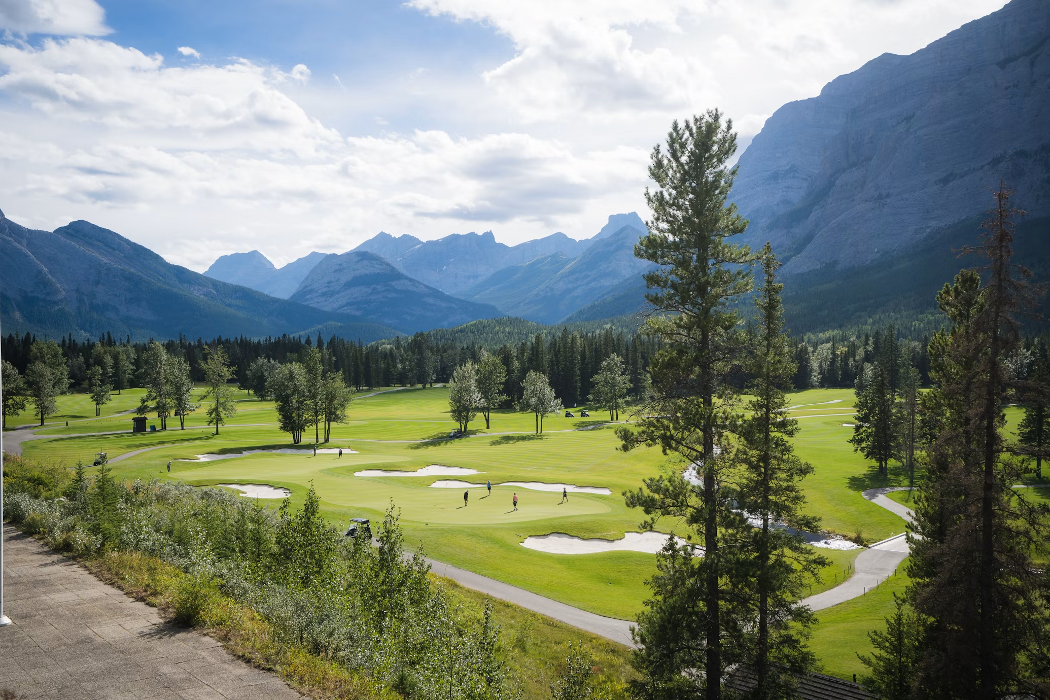 Aerial view of course surrounded by pine forest and mountains
