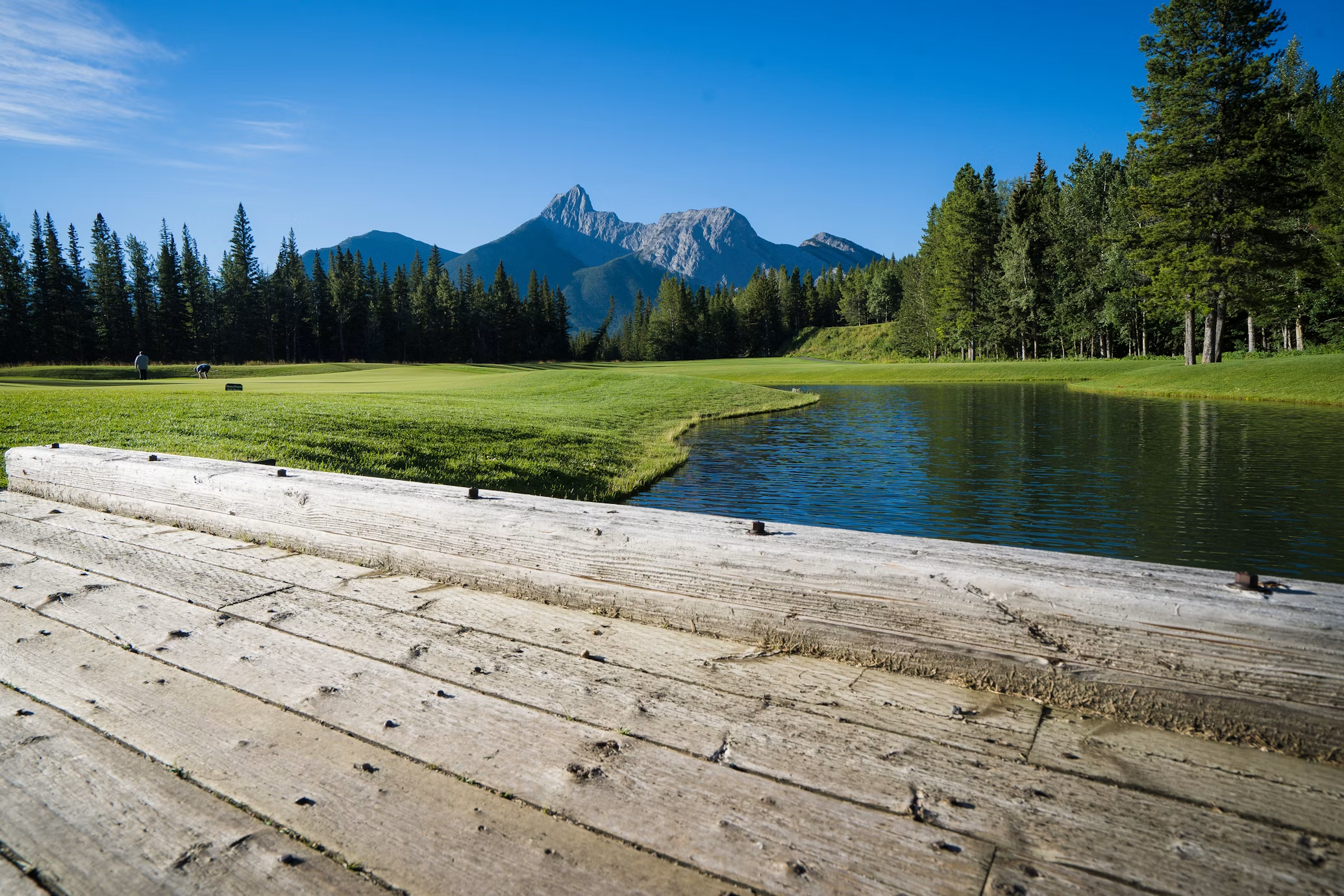 Wooden bridge overlooking mountain golf course lake
